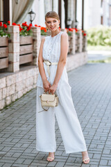 A girl in a light summer suit with a bag. Demonstration of clothing