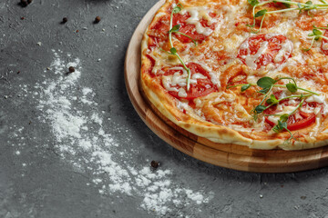 Pizza Margherita on black stone background, top view. Pizza Margarita with Tomatoes, Basil and Mozzarella Cheese close up