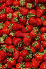 Fresh ripe perfect strawberry - Food Frame Background. Fresh strawberry as texture background. Natural food backdrop with red berries. Strawberries sale in a food market in summer.
