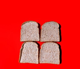 Wholemeal bread slices on red background. healthy food concept