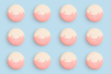 Macaroons pattern on colored background, twelve colorful french cookies macarons. Beige, pink french cookies macarons on mint blue background. Gift for congratulations.