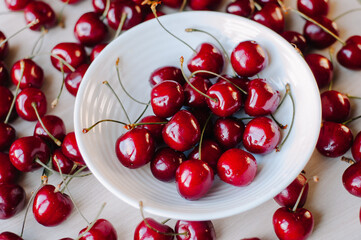 Cherry berry on a white plate . Summer berry. Berries on a plate on a white background. Article...