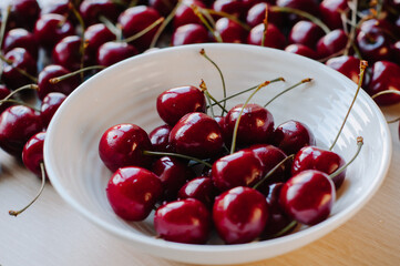 Cherry berry on a white plate . Summer berry. Berries on a plate on a white background. Article about berries. The berry season.