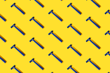 pattern of many copy pasted plastic blue shaver razors on yellow background . top side view. minimal pop up style. Banner, desktop, print, wallpaper. High quality photo