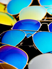 Sunglasses with colorful lenses on black background