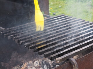 Smoking grill grate smeared with oil. smoke. outdoor recreation.