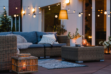 Fototapeta Summer evening on the patio of beautiful suburban house with lights in the garden garden obraz
