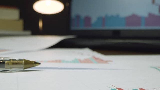 Close Up Stock Market Graphs on Desk at Night