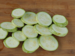 the cook cuts zucchini into circles on a wooden Board