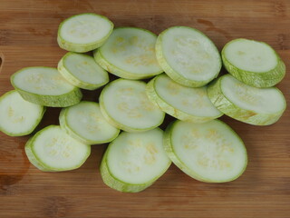 the cook cuts zucchini into circles on a wooden Board