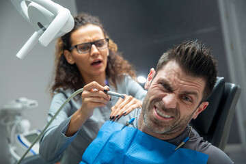 Attractive young woman in stomatology clinic with male dentist. Healthy teeth concept.
