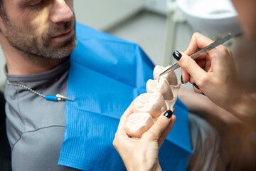 Attractive young woman in stomatology clinic with male dentist. Healthy teeth concept.
