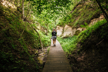 Woman person walking on hiking trail of Hinni canyon, cliff made out of an sand in Estonia. © FotoHelin
