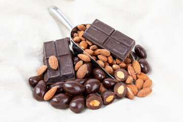 a baker's scoop of plain roasted almonds and chocolate covered almonds with chunks of unmelted baker's chocolate