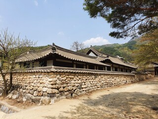 Fototapeta premium Korean building surrounded by mountains under a blue sky