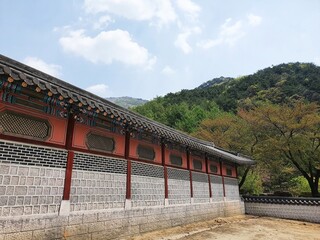 Korean building near a forested mountain
