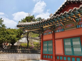 Traditional Korean building near trees under a blue sky