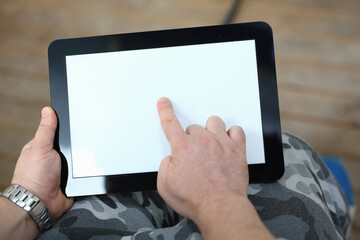 Top view of male holding tablet while pushing a finger on the screen. Technology concept