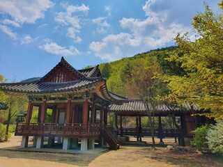 Obraz premium Traditional Korean building near a forested mountain
