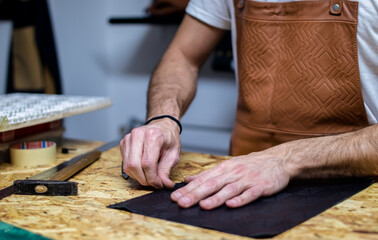 Fototapeta na wymiar craftsman hands cutting the leather 
