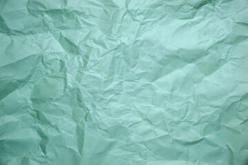 Close up of green crumpled empty sheet of paper.