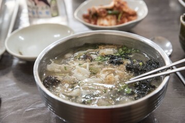 Closeup shot of a bowl with tasty Korean noodle soup at a restaurant