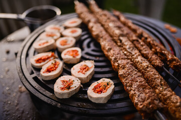 Roasted minced kebab with rolled white meat stuffed with vegetables. Barbecue and outdoor party