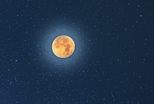 Beautiful full yellow moon, on the blue starry sky. Astronomical background. Night photography.
 