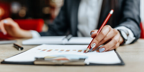 Business woman checks charts and refreshes financial progress. The girl analyzes the business model in the workplace.