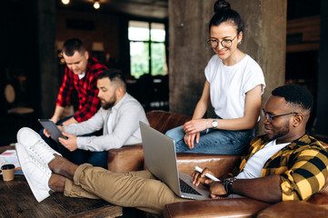 Modern creative office. Brainstorming a young successful business team in their office space. They divided into groups to develop new ideas and projects