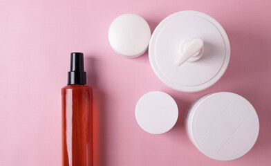 different cosmetic products for skin, body or hair care on pink background. flat lay, minimalism