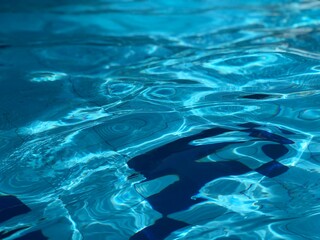 Blue pool water with sun reflections.Abstract background of water.