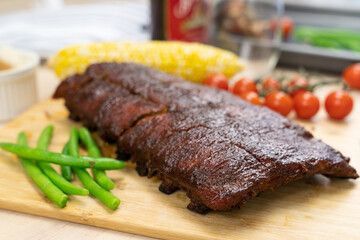 Oven baked BBQ pork ribs with sweet corn, bean and tomato