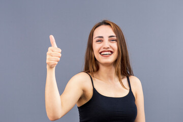 Portrait of laughing beautiful Turkish young woman makes okay gesture, indicates agreement and that everything is fine, with warm and positive mood, awesome emotions. Gestures and emotions concept.