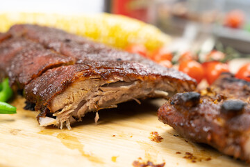 Oven baked BBQ pork ribs with sweet corn, bean and tomato