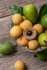 Ripe longan and feijoa on an old wooden background. Exotic fruits