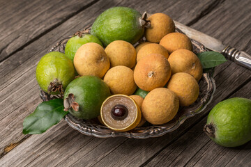 Ripe longan and feijoa on an old wooden background. Exotic fruits