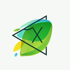 X letter logo in triangle frame at green leaves watercolor background.