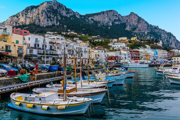 Fototapeta na wymiar Sailing boats line the quayside of Marina Grande with Mount Solaro in the distance on the island of Capri, Italy