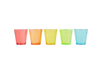 Multi-colored glasses standing in a row on a white background. Recycled material