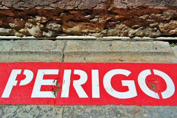 Danger, Perigo sign with stone background