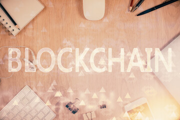 Double exposure of blockchain theme hologram over table with phone. Top view. Crypto technology concept.