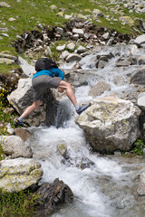 man drinking water from a mountain river on a excursion day