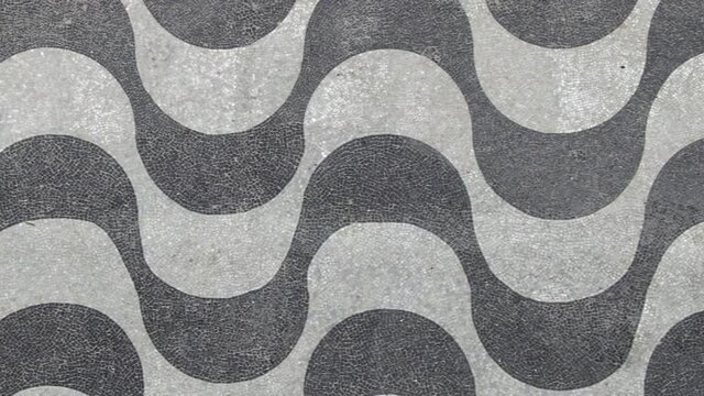 Rio de Janeiro, Brazil, top view of iconic wave pattern mosaic sidewalk at Copacabana Beach. 