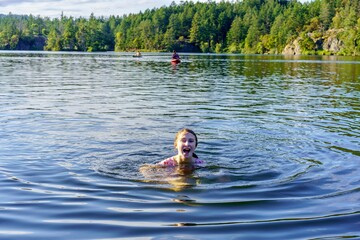Smiling girl in the ripples of lake water - Thetis Lake, British Columbia 