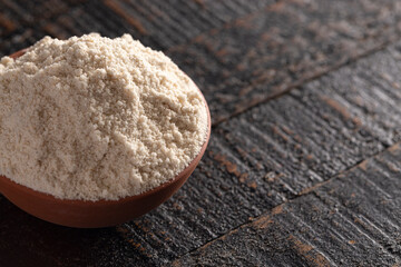 Fototapeta na wymiar Bowl of Sprouted Sorghum Flour on a Dark Wood Background