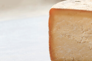 Half homemade cheese wheel on the dark wooden background. Side view.