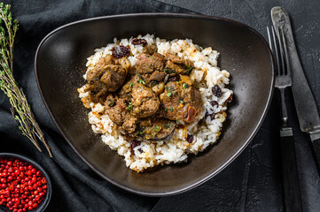 Greek style lamb stew in a tomato, with rice.  Black background. Top view