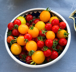 Yellow and red cherry organic tomatoes in a pottery bowl 