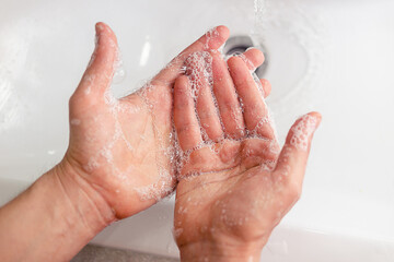 Closeup of person washing hands with soap.